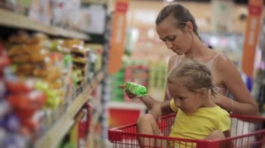 Anne küçük kızı aperatifler tatlılar bölümünde süpermarkette seçimi ile