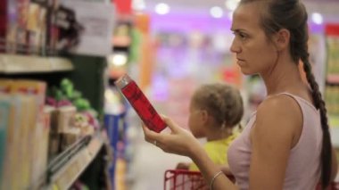 Anne küçük kızı aperatifler tatlılar bölümünde süpermarkette seçimi ile
