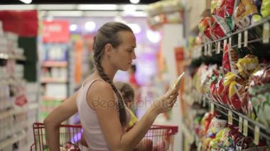 Anne küçük kızı aperatifler tatlılar bölümünde süpermarkette seçimi ile