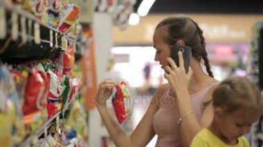 Anne küçük kızı aperatifler tatlılar bölümünde süpermarkette seçimi ile