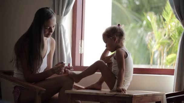 Mom put on nail polish on daughters nails on the feet — Stock Video