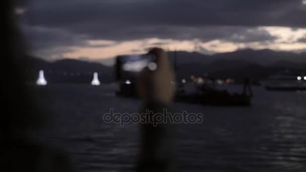 Mujer tomando fotos de la vista nocturna a través del teléfono móvil — Vídeos de Stock