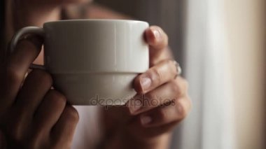 Pencerenin oturan ve çay içme genç çekici kadın