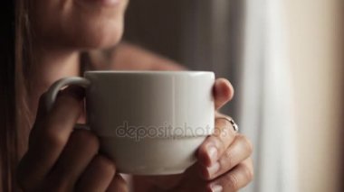 Pencerenin oturan ve çay içme genç çekici kadın