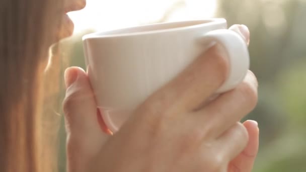 Jovem mulher atraente bebendo café ou chá na varanda, close-up — Vídeo de Stock