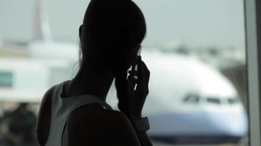 Havaalanında uçak arka planda ile akıllı telefon olan kadın