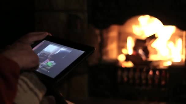 Hombre mayor se sienta en la chimenea con la tableta y ver vídeo familiar — Vídeo de stock