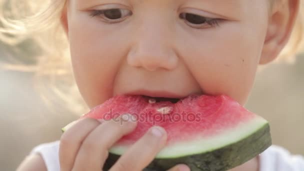 Retrato de cerca de la pequeña niña linda comer sandía roja al amanecer — Vídeos de Stock