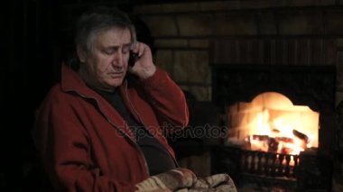 Komuta sizde tarafından cep telefonu şömine yakın sandalye üzerinde oturan konuşma