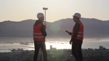 Dağın tepesinde jeodezik ölçümleri performans kask içinde iki arazi