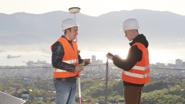 Dělníci v helmě geodetické měření na vrcholu hory. — Stock video
