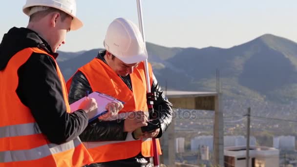 Inspektoři provádějící geodetické měření a jejich upevnění do papíru — Stock video