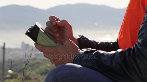 Man in oranje vest werken met geodetisch apparatuur. Close-up shot — Stockvideo