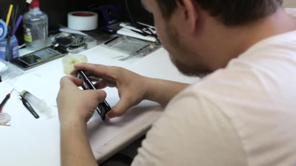 Чоловічий майстер розбирання смартфона для змін зламаних деталей — стокове відео