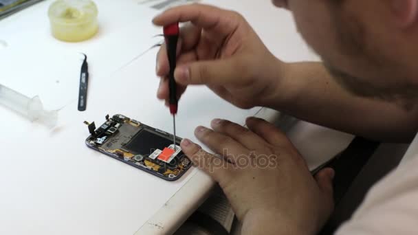 Masculino mestre desmontagem inteligente telefone para mudança quebrado detalhes — Vídeo de Stock