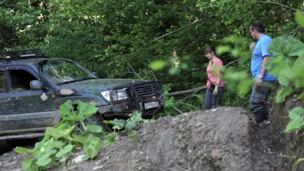 Expeditionary Suv kör långsamt genom ett dike i skogen. — Stockvideo