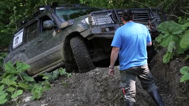 SUV expedicionário dirigindo lentamente através da área perigosa na floresta . — Vídeo de Stock