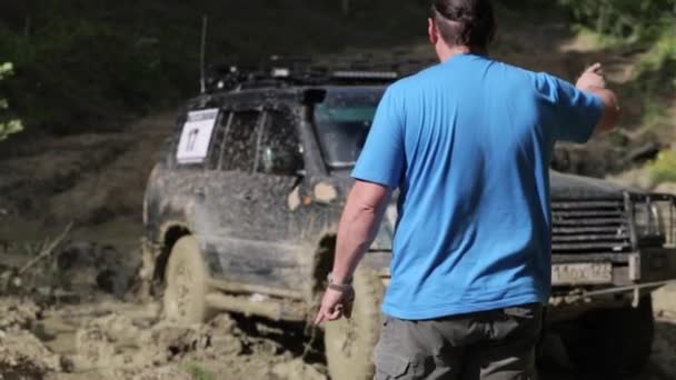 SUV ficou preso na lama e tentando sair via guincho na floresta . — Vídeo de Stock