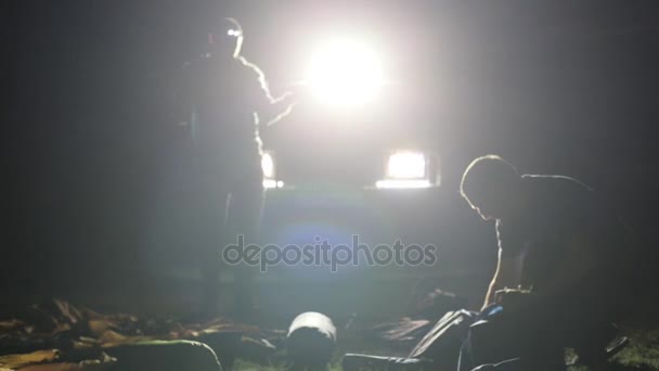 Noční snímek dvou mans převracející stanu v ligh z expediční Suv. — Stock video