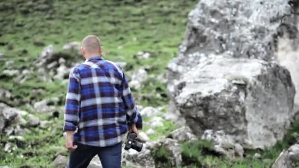 Fotograaf neemt foto's van dieren in het wild in de mouintains. — Stockvideo