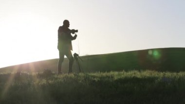 Kamera ve tepenin üst kısmında tripod ile çekim fotoğrafçı.