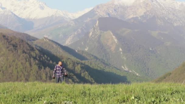 Wildlife natuurfotograaf wandelen met statief in berglandschap — Stockvideo