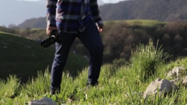 Мандрівник в альпіністських черевиках, що ступають на камені в гірському пейзажі — стокове відео