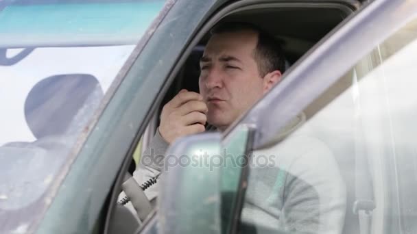 Homem segurando microfão mão e falando no rádio em seu carro . — Vídeo de Stock