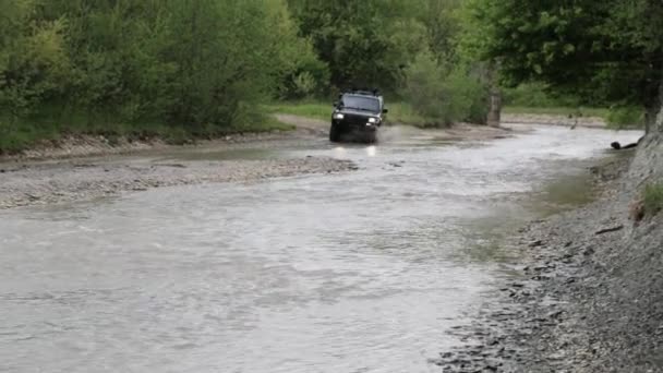 SUV spedizione attraversare il fiume con velocità veloce e spruzzi — Video Stock