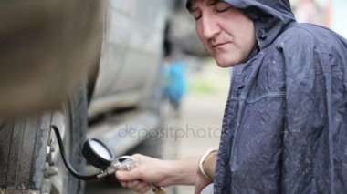 Erkekte Suv Jantlar yol kenarında pompalama yağmurluk