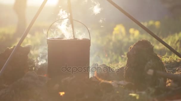 Γκρο πλαν του δοχείου με το φαγητό που κρέμεται πάνω από τη φωτιά — Αρχείο Βίντεο