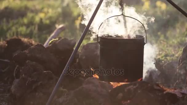 Zbliżenie: garnek z żywności wisi nad ogniem — Wideo stockowe