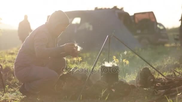 Caucásico hombres cocinar comida en boowler en hoguera en camping . — Vídeos de Stock