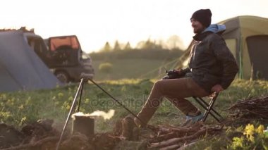 Şenlik ateşi ve çekici fotoğraf yolu ile profesyonel fotoğraf makinesi yanında oturan Gezgin.