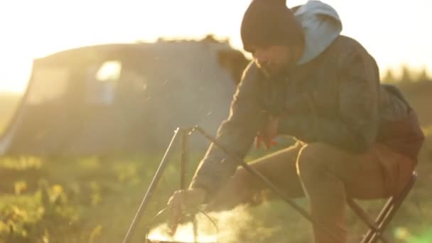 Caucásico hombres cocinar comida en boowler en hoguera en camping . — Vídeos de Stock