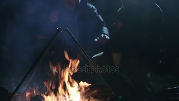 Nacht schot van twee Kaukasische vrienden hebben een discussie naast kampvuur. — Stockvideo