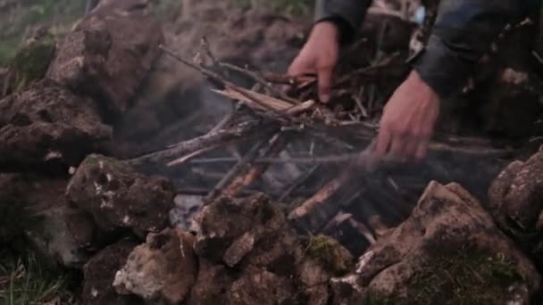 Człowiek zaczyna się przy ognisku na obozie — Wideo stockowe