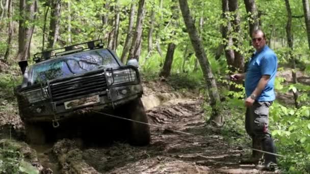 Expeditionary SUV got stuck in the forest and trying to get out via winch. — Stock Video