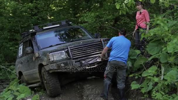 Expediční Suv se snaží překonat nebezpečné složitý terén v lese přes naviják. — Stock video