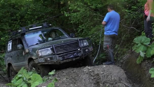 Expeditionary SUV trying overcom dangerous complex terrain at forest via winch. — Stock Video