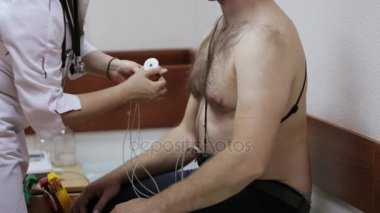 Kadın Doktor hastanın göğsüne elektrotlar günlük izleme için ekleme