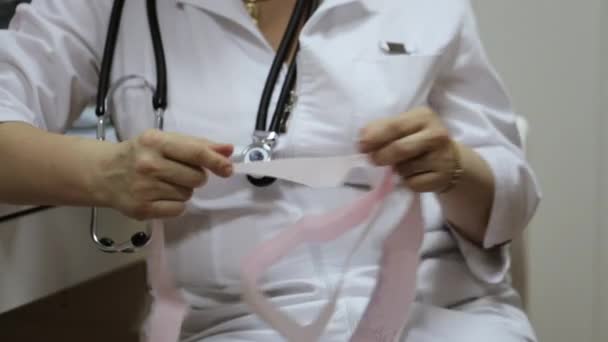 Arzt überprüft Papier mit Elektrokardiogramm im Medizinschrank — Stockvideo