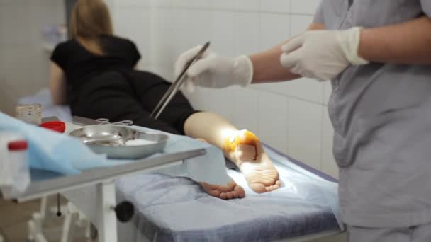 Γιατρός bandaging ένα πόδι γυναίκες ασθενείς, στο ιατρείο. — Αρχείο Βίντεο