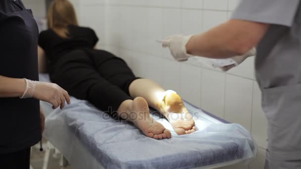 Bandážování nohy pacientky v ordinaci lékaře. — Stock video