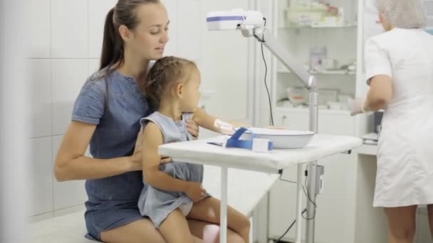 Ragazza seduta con la madre mentre l'infermiera la prepara per prendere il suo sangue per il test — Video Stock