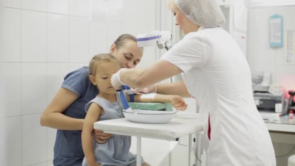 Flickan sitter med mor medan sjuksköterska prepair henne för att ta sitt blod för test — Stockvideo