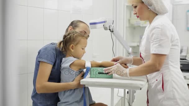 Ragazza seduta con la madre mentre l'infermiera la prepara per prendere il suo sangue per il test — Video Stock