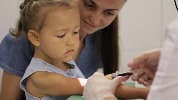 Menina com a mãe no hospital. Enfermeira levando meninas sangue venoso para teste — Vídeo de Stock