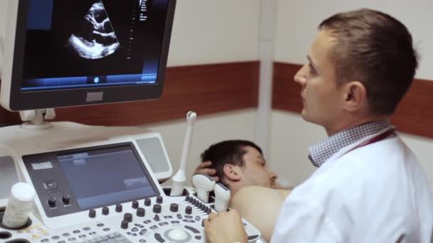 Medico prendendo un sonogramma e guardando sullo schermo del dispositivo a ultrasuoni . — Video Stock