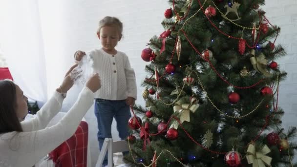 Mother and daughter decorating Christmas tree in eve the New Year holiday — Stock Video